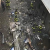 Lính cứu hỏa Mỹ làm nhiệm vụ tại hiện trường máy bay trực thăng gặp nạn khi hạ cánh ở New York. (Nguồn: AFP/TTXVN)