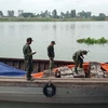 Cán bộ, chiến sỹ Đồn Biên phòng cửa khẩu Long Bình đang kiểm tra số phế liệu vừa bắt giữ. (Ảnh: Công Mạo/TTXVN)