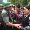 Trưởng ban Tổ chức Trung ương Phạm Minh Chính động viên, thăm hỏi người dân bản Sa Ná. (Ảnh: Nguyễn Nam/TTXVN)