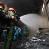 Cảnh sát căng mình dập lửa tại Khu công nghiệp Sài Đồng. (Ảnh: Lê Minh Sơn/Vietnam+)