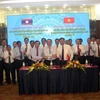 Trưởng đoàn đại biểu ba tỉnh Quảng Trị, Savannakhet, Salavan bắt tay đoàn kết, hữu nghị sau khi ký kết văn bản thỏa thuận hợp tác. (Ảnh: Trịnh Bang Nhiệm/TTXVN)