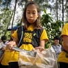 Cô bé Ralyn Satidtanasarn (thứ 2, phải) tham gia dọn rác tại khu vực Khung Bang Kachao, Bangkok, Thái Lan. (Ảnh: AFP/TTXVN)