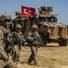Binh sỹ Mỹ và xe quân sự của Thổ Nhĩ Kỳ tham gia cuộc tuần tra chung ở ngoại ô thị trấn Tal Abyad (Syria) giáp giới với Thổ Nhĩ Kỳ. (Ảnh: AFP/TTXVN)
