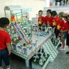 Phụ huynh học sinh và các em nhỏ thích thú xem các đồ dùng, đồ chơi, mô hình từ vỏ hộp sữa đã qua sử dụng tại Ngày hội SHĐ Đà Nẵng.