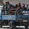 Người dân Syria sơ tán tránh chiến sự tại thị trấn Ras al-Ain. (Ảnh: AFP/TTXVN)