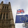 Quốc kỳ Anh (phía trên) và cờ Liên minh châu Âu (phía dưới) bên ngoài tòa nhà Quốc hội Anh ở London. (Ảnh: THX/TTXVN)