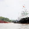 Phương tiện lai dắt container vào tập kết gần bờ, tạo thông thoáng cho lòng sông Lòng Tàu. (Ảnh: Tiến Lực/TTXVN)