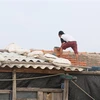 Người dân phường Phú Đông, thành phố Tuy Hòa, Phú Yên gia cố lại mái nhà để ứng phó với bão số 6. (Ảnh: Phạm Cường/TTXVN)