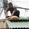 Công tác gia cố lại nhà ở để đảm bảo an toàn trước khi bão đổ bộ đang được người dân tỉnh Phú Yên khẩn trương thực hiện. (Ảnh: Phạm Cường/TTXVN)