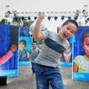 Trẻ nhỏ Thủ đô tại triển lãm ảnh Thắp sáng nụ cười Việt Nam. (Ảnh: Thành Đạt/TTXVN)