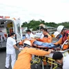 Đội ngũ y tế nhanh chóng đưa bệnh nhân Makino Tsuneji đến bệnh viện tiếp tục điều trị ngay sau khi tàu cứu nạn cập cảng Nha Trang. (Ảnh: Nguyễn Dũng/TTXVN)
