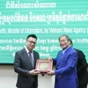 Bộ trưởng Bộ Thông tin Campuchia Khieu Kanharith chụp ảnh lưu niệm với đoàn đại biểu TTXVN. (Ảnh: Nguyễn Hùng/Vietnam+)