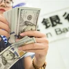 Kiểm đồng USD tại một ngân hàng ở Giang Tô, Trung Quốc. (Ảnh: AFP/TTXVN)