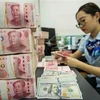 Kiểm đồng 100 nhân dân tệ tại ngân hàng ở tỉnh Giang Tô,Trung Quốc. (Ảnh: AFP/TTXVN)