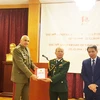 Trưởng Cơ quan tùy viên Quốc phòng Việt Nam tại Bulgaria Nguyễn Tuấn Anh trao Sách trắng cho Trung tướng Dimitar Iliev. (Ảnh: Công Thuận/Vietnam+)