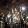 Người dân đón thời khắc giao thừa trong lễ hội năm mới ở tòa tháp đôi Petronas, Kuala Lumpur, Malaysia. (Ảnh: THX/TTXVN)