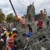 Lực lượng cứu hộ tìm kiếm nạn nhân dưới đống đổ nát sau vụ sập công trình xây dựng ở chùa Prasat Korkchak thuộc tỉnh Siem Reap, Campuchia. (Ảnh: THX/TTXVN)