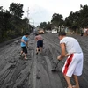 Người dân dọn tro bụi phun trào từ núi lửa Taal ở thị trấn Tanauan, tỉnh Batangas, Philippines. (Ảnh: AFP/TTXVN)