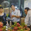 Cán bộ Ban Quản lý an toàn thực phẩm Thành phố Hồ Chí Minh kiểm tra trái cây, hóa đơn mua bán tại Chợ nông sản Thủ Đức. (Ảnh: Đinh Hằng/TTXVN)