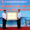 Các tổ chức, cá nhân trao tặng các tư liệu, hiện vật cho Chủ tịch Ủy ban Nhân dân huyện Hoàng Sa Võ ngọc Đồng (bên phải) tại buổi tiếp nhận. (Ảnh: Trần Lê Lâm/TTXVN)
