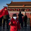 Em nhỏ tại quảng trường Thiên An Môn ở Bắc Kinh, Trung Quốc đeo khẩu trang đề phòng virus corona mới. (Ảnh: AFP/TTXVN)
