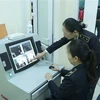 Cán bộ Trung tâm Kiểm dịch Y tế Quốc tế Quảng Ninh kiểm tra trên máy đo thân nhiệt từ xa và quan sát tình trạng sức khỏe của hành khách nhập cảnh từ Trung Quốc vào Việt Nam tại cửa khẩu Móng Cái (thành phố Móng Cái, tỉnh Quảng Ninh). (Ảnh: Minh Đông/TTXVN