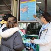 Nhân viên Trạm hỗ trợ khách du lịch (Trung tâm thông tin xúc tiến du lịch Ninh Bình) tuyên truyền về phòng chống dịch bệnh nCoV tại khu du lịch sinh thái Tràng An. (Ảnh: Đức Phương/TTXVN)