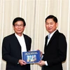 Ông Trần Vĩnh Tuyến, Phó Chủ tịch UBND Thành phố Hồ Chí Minh tặng quà ông Shimo Hiroshi, Phó Thống đốc tỉnh Wakayama, Nhật Bản. (Ảnh: Xuân Khu/TTXVN)