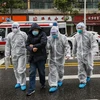 Nhân viên y tế đưa bệnh nhân nhiễm virus corona vào bệnh viện để điều trị tại Hồ Bắc, Trung Quốc. (Ảnh: AFP/TTXVN)