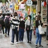 Người dân đeo khẩu trang phòng tránh dịch viêm đường hô hấp cấp COVID-19 khi đi dạo tại khu phố mua sắm ở Okinawa, miền Nam Nhật Bản. (Ảnh: Kyodo/TTXVN)