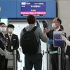 Hành khách trở về Mỹ được kiểm tra thân nhiệt nhằm ngăn chặn sự lây lan của dịch COVID-19 tại sân bay quốc tế Incheon, Hàn Quốc. (Ảnh: YONHAP/TTXVN)