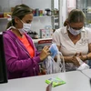 Người dân mua khẩu trang và dung dịch sát khuẩn tại một cửa hàng ở Caracas, Venezuela. (Ảnh: AFP/TTXVN)
