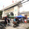 Tại cổng số 1 Bệnh viện Bạch Mai mọi hoạt động vẫn bình thường, người dân khi vào cổng sẽ được đo kiểm tra thân nhiệt và sát khuẩn tay. (Ảnh: Minh Quyết/TTXVN)