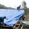 Lực lượng chức năng dựng lại nhà cho nhân dân sau cơn dông kèm mưa đá tại xã Phúc Khánh. (Ảnh: Quốc Khánh/TTXVN)