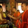 Các sư sãi thực hiện nghi thức tắm Phật tại chùa Khmer. (Ảnh: Trung Hiếu/TTXVN)