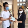 Phó Giám đốc Sở Y tế tỉnh Vĩnh Long Hồ Thị Thu Hằng trao giấy chứng nhận hoàn thành cách ly cho người dân. (Ảnh: Lê Thúy Hằng/TTXVN)