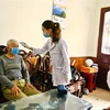 Nhân viên y tế tại Quảng Ninh đo thân nhiệt, khám sức khỏe cho người cao tuổi. (Ảnh: Minh Quyết/TTXVN)