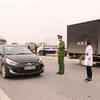 Các lực lượng chức năng dừng xe kiểm soát dịch bệnh tại điểm chốt cầu Như Nguyệt, thành phố Bắc Ninh, tỉnh Bắc Ninh trên cao tốc Hà Nội-Bắc Giang. (Ảnh: Thanh Thương/TTXVN)