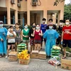 Đại diện Ban liên lạc và Câu lạc bộ Phụ nữ Việt Nam tại Malaysia (hai người mặc áo bảo hộ màu xanh) trao quà hỗ trợ đến bà con gặp khó khăn. (Ảnh: Hoàng Đình Nhương/TTXVN)