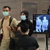 Hành khách đeo khẩu trang để phòng tránh lây nhiễm COVID-19 tại sân bay quốc tế Changi, Singapore. (Ảnh: AFP/TTXVN)