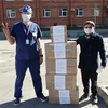 Đại diện cộng đồng người Việt Nam ở St. Petersburg chuyển tất y tế chuyên dụng tặng Bệnh viện. (Ảnh: TTXVN phát)