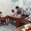 Thầy giáo Lê Xuân Quyết hướng dẫn học sinh xã đảo Song Tử Tây. (Ảnh: Dương Giang/TTXVN)