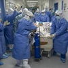 Nhân viên y tế chuyển bệnh nhân mắc COVID-19 tới phòng điều trị tích cực tại một bệnh viện ở Vũ Hán, Trung Quốc ngày 12/4. (Ảnh: THX/TTXVN)