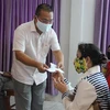 Ông Võ Tuấn Ngọc, Lãnh đạo Tổ Công tác cộng đồng Đại sứ quán Việt Nam, trao hàng cứu trợ cho bà con gốc Việt tại Campuchia. (Ảnh: TTXVN/phát)