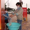 Công nhân lấy gạo miễn phí tại cây ATM gạo tại Khu công nghiệp Quế Võ, tỉnh Bắc Ninh. (Ảnh: Thái Hùng/TTXVN)