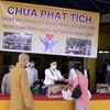 Để phòng chống dịch COVID-19, việc trao quà được tiến hành cho từng người một, đúng theo yêu cầu giãn cách của Bộ Y tế Lào. (Ảnh: Phạm Kiên/Vietnam+)