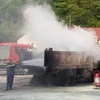 Lực lượng cứu hộ cố gắng cứu chiếc xe bị cháy. (Ảnh: TTXVN phát)