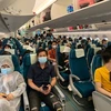 Các công dân Việt Nam trên tàu bay của Vietnam Airlines, chuẩn bị lên đường về nước. (Ảnh: Hà Ngọc/TTXVN)