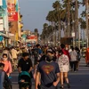 Người dân đi dạo trên bãi biển ở California, Mỹ sau khi lệnh hạn chế nhằm ngăn dịch COVID-19 lây lan được nới lỏng, ngày 22/5. (Ảnh: AFP/TTXVN)