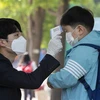 Kiểm tra thân nhiệt cho học sinh tại trường tiểu học ở Seoul, Hàn Quốc. (Ảnh: THX/TTXVN)